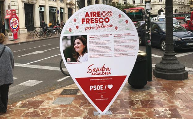 Uno de los carteles electorales de Sandra Gómez, atornillado en una acera. 