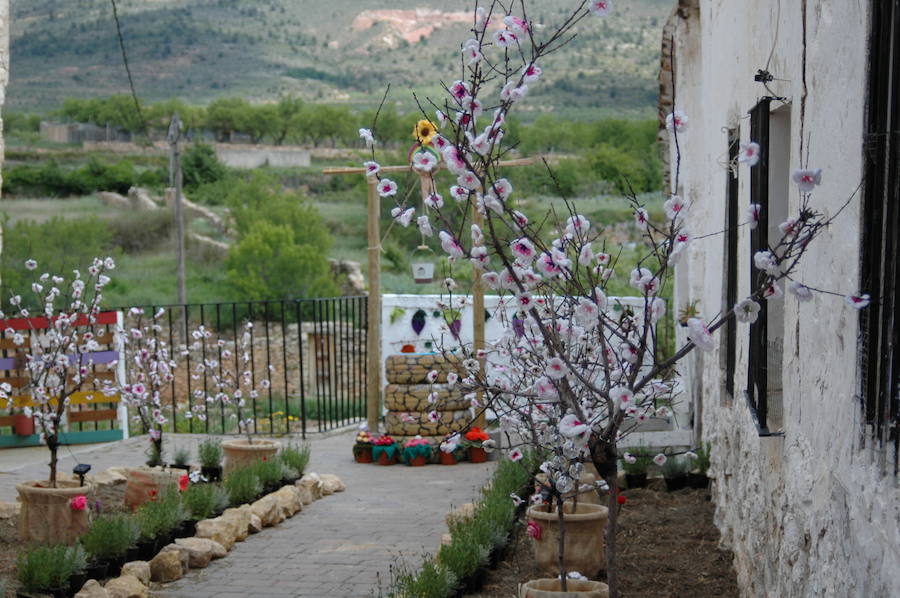 Los aromas y colores de las flores se han adueñado de Aras de los Olmos (Valencia). Durante la primavera, esta localidad situada Los Serranos cubre sus calles, fachadas con cientos de plantas y arte efímero. La exposición de las propuestas presentadas en «Aras en flor» se podrá visitar hasta el 30 de junio Los diseñadores de paisajes han tenido que defender la sostenibilidad, belleza y creatividad de la propuesta. Además de combinar flores y plantas con materiales del entorno utilizados históricamente por los vecinos y vecinas. Esta pequeña localidad del interior de la Comunitat Valenciana aguarda entre montes como un remanso de paz que fue poblado por íberos, romanos y árabes, Incluso, formó parte de la Orden de Montesa en 1318. Y todas estas culturas se han quedado guardadas entre sus callejuelas. 