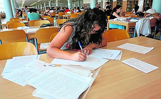 Una estudiante, en una biblioteca preparando sus exámenes.