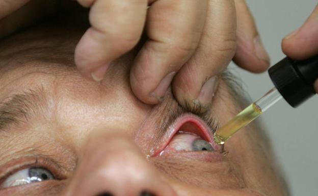 Un hombre se aplica en el ojo unas gotas.