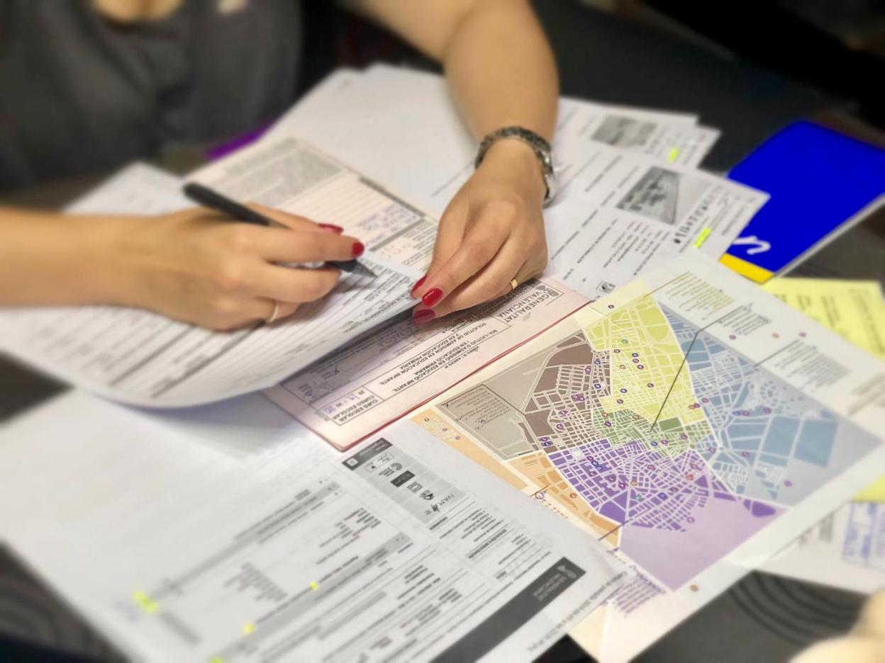 Mari Carmen, en su casa de Castellón, con mapas de las áreas de influencia, impresos oficiales de la admisión y fichas de centros. 