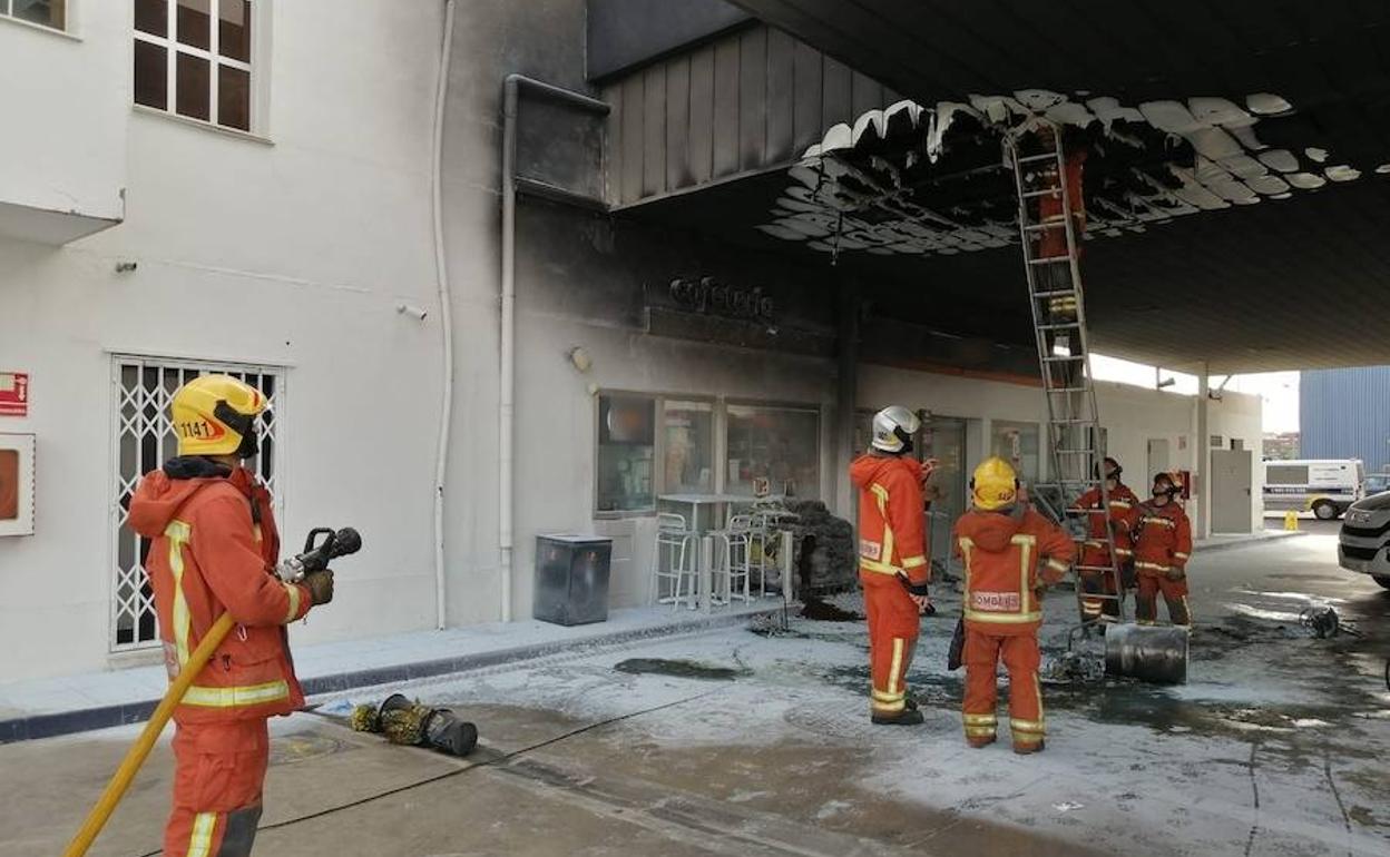 Los bomberos trabajan en la zona afectada por las llamas, en la gasolinera de Mislata.