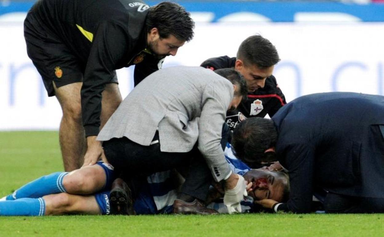 Álex Bergantiños, atendido en el césped del estadio de Riazor. 