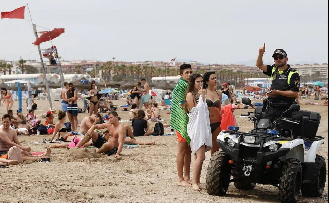 La Policía expulsa de la playa de la Malvarrosa a los bañistas. 