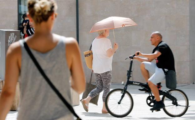 Una mujer se protege del sol con un paraguas en Valencia. 