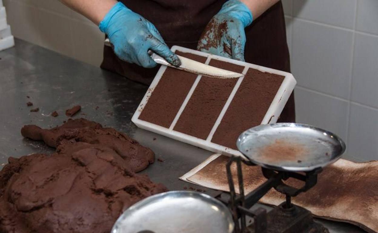 Un empleado elabora una tableta de chocolate. 