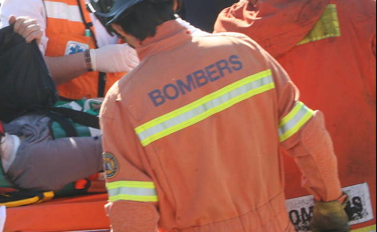 Bomberos atienden a un herido en un accidente. 