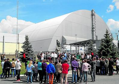 Imagen secundaria 1 - En el blanco y negro liquidadores. Segunda imagen, visitantes ante el sarcófago del reactor número 4. última imagen, una tiurista mide su grado de contaminación. 