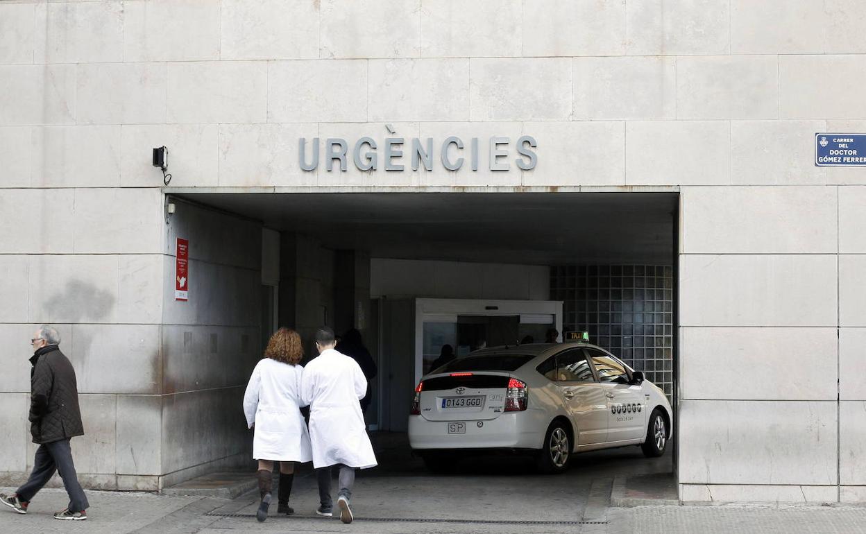 Dos profesionales entran en el Hospital Clínico.