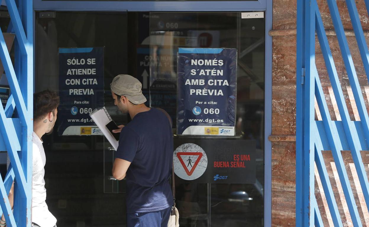 Dos jóvenes a las puertas de la Jefatura Provincial de Tráfico de Valencia.