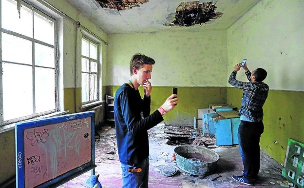 Turistas fotografían el interior de una guardería abandonada en el pueblo de Kopachi, cerca de la central.