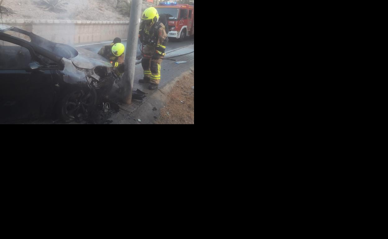 Bomberos de Alicante, junto al coche quemado.