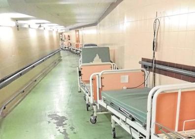 Imagen secundaria 1 - Dos ambunacias segundos despúes de tener un pequeño roce. Una puerta y un tablón de madera en el hueco de una escalera en el Hospital Clínico. Desconchones en el suelo del sótano del hospital y varias camas viejas. 