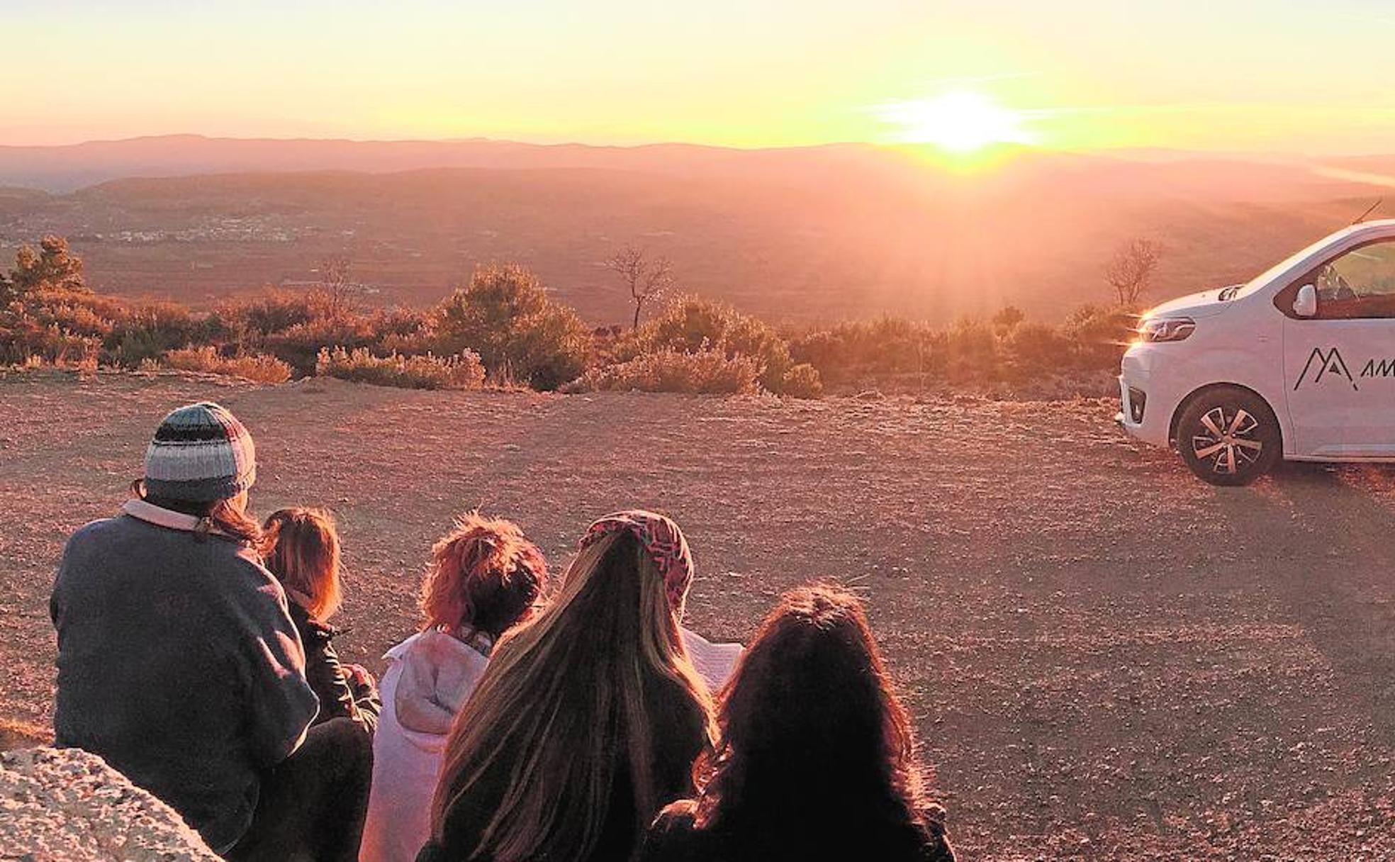 Un grupo de jóvenes excursionistas observan la caída del sol en Aras de los Olmos. 