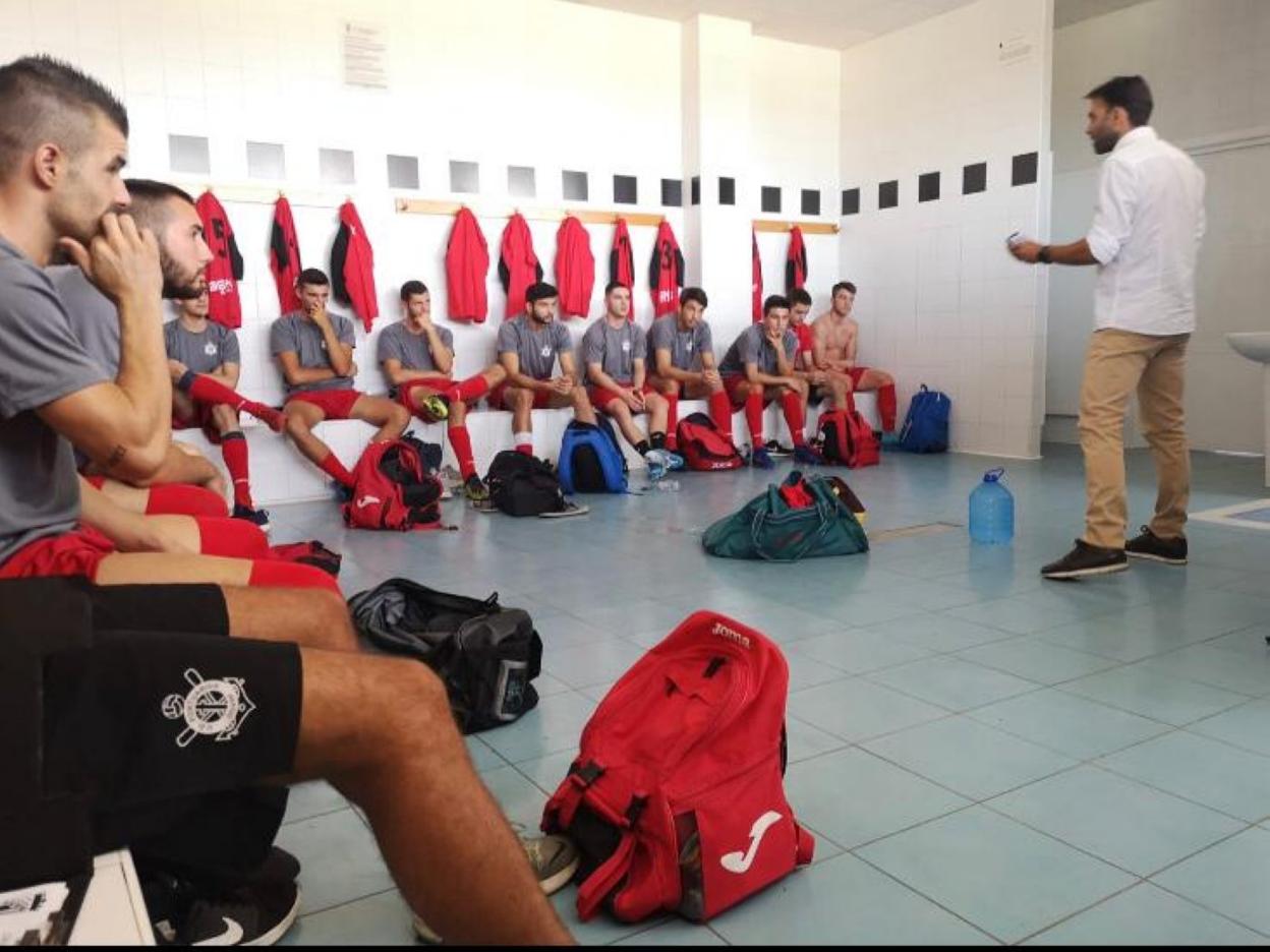 El técnico de la UD Portuarios, Salva Moratal, con sus jugadores en el vestuario. 