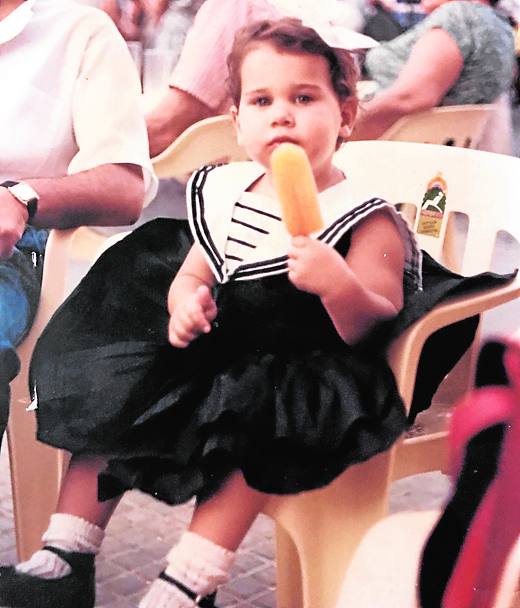Iris de pequeña comiendo un helado. Le encantaba gastar bromas y contar historias.