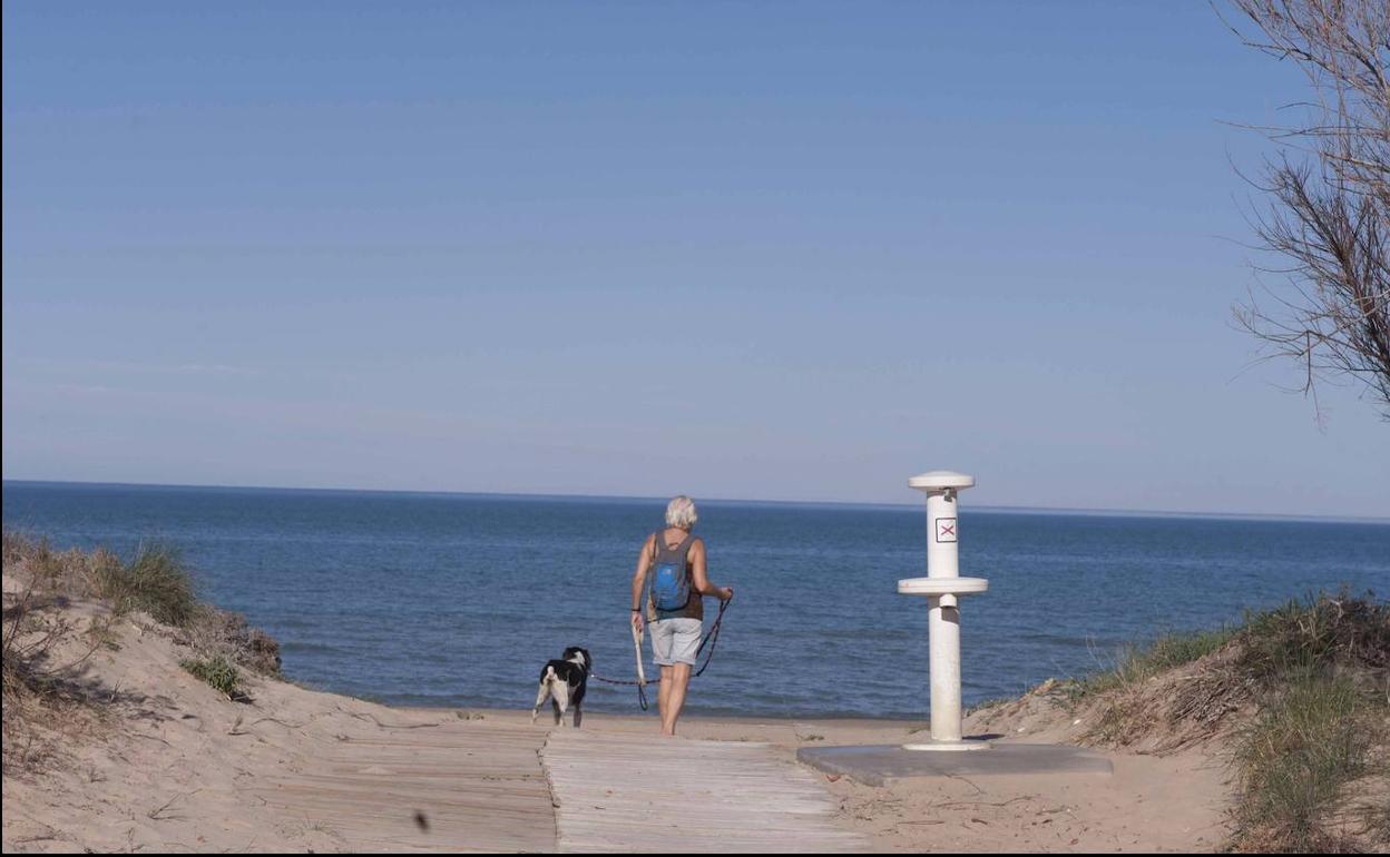 Un hombre accede a una de las playas de Oliva.