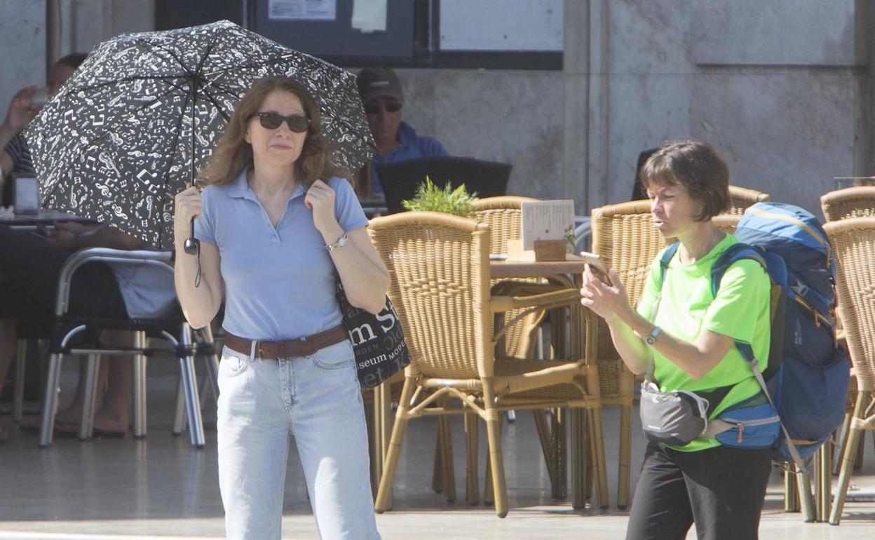 Una mujer se protege del sol en Valencia.