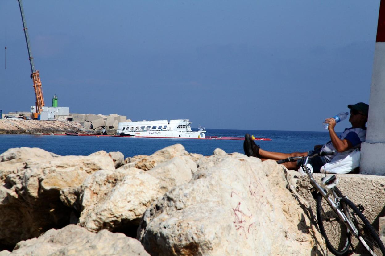 El ferry encallado en Dénia, que lleva un mes y medio en la escollera norte, ya no presenta la parte superior del buque, que ha sido retirada. 