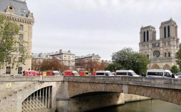 Imagen principal - Calles cortadas en París, coches de policía y de los servicios de emergencias, y un helicóptero. 