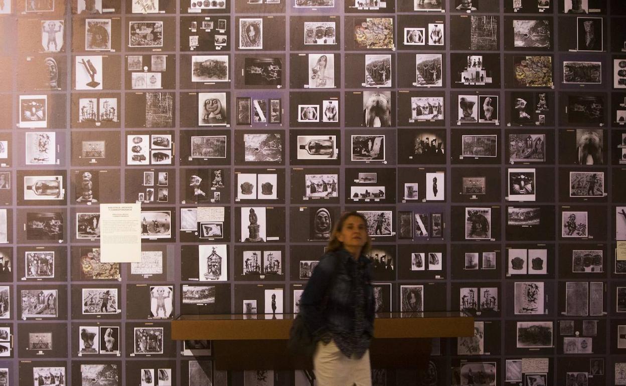 Una mujer delante de la pared empapelada con fotografías en la exposición 'Jean Dubuffet. Un bárbaro en Europa'. 