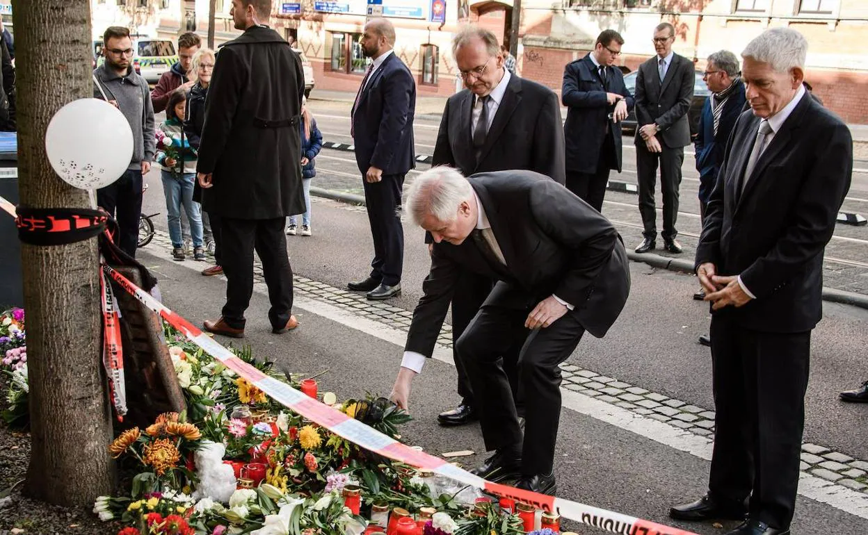 El ministro de Interior de Alemania, Horst Seehofer, deposita unas flores en el lugar del ataque.