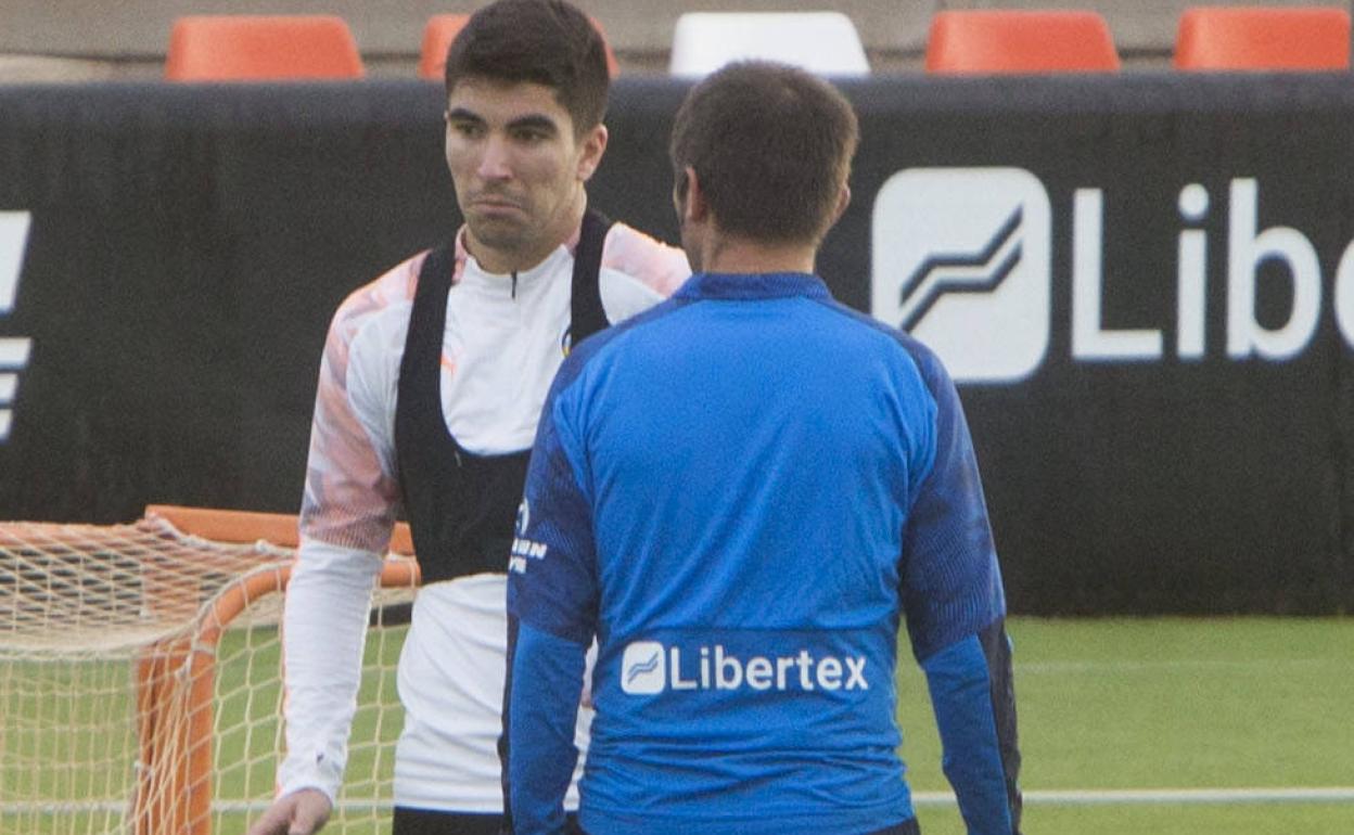 Carlos Soler charla con Celades en un entrenamiento del Valencia 