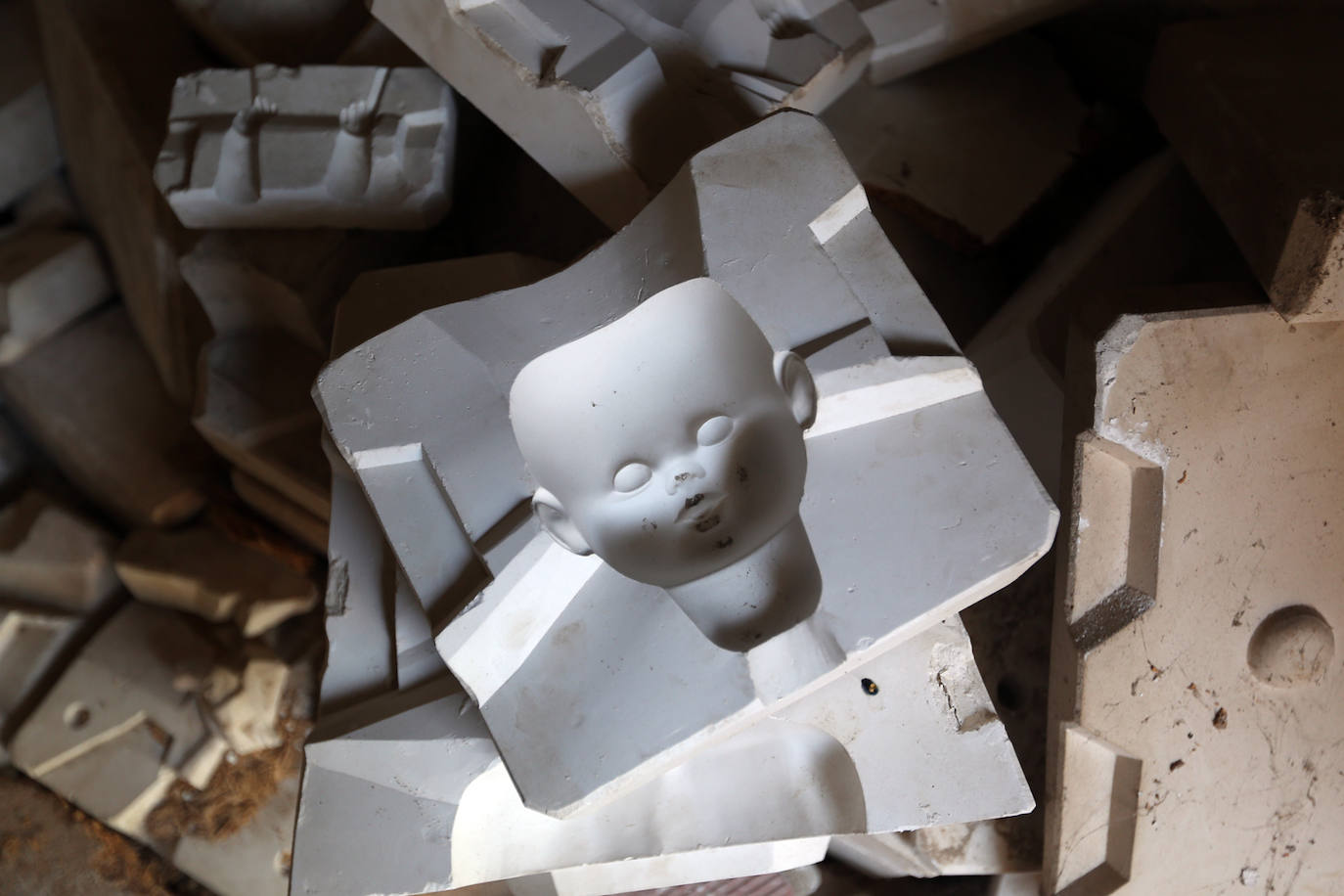 La fábrica de muñecas de porcelana abandonada (Castellón) | Es una de las paradas por excelencia de la ruta del 'terror' en la Comunitat, situada en un municipio de la provincia de Castellón y conocida más allá de las lindes mediterráneas por el morbo que despierta lo que un día fue. Y también lo que sigue siendo. Porque aunque sus ruinas están ya en un estado muy crítico y potencialmente peligroso para cualquier visitante, el atractivo de las muñecas de porcelana atrae a multitud de curiosos y amantes de lo paranormal. Aunque ya no queda ningún juguete íntegro, el panorama presenta cientos de moldes rotos, trozos de cerámica apilados, pintadas, trozos de pelucas y hasta lo que parecen restos de sangre de alguien que subestimó el riesgo de adentrarse en el lugar. En el edificio todavía se pueden apreciar moldes completos de algunas partes del cuerpo de los juguetes, como la cara, o el brazo, que permiten hacerse una idea del escalofriante detalle con el que se construían las muñecas del escultor y porcelanista Ramón Inglés. Junto a su hermana Josefina, puso en marcha esta fábrica en la década de los 70, Por entonces ya eran dos escultores reconocidos en el sector y la fábrica funcionó a la perfección durante muchos años, en los que se constituyeron como auténticos maestros en el arte de estas figuras. Hasta que llegaron los ochenta. Es en esta década cuando la empresa Lladró irrumpe con fuerza en la industria de la porcelana y va ganando terreno a los hermanos Inglés. La estocada final llegó el 3 de mayo de 1997, con la muerte de Ramón, que supuso el cierre definitivo de la fábrica. Desde entonces, la fábrica permanece como un referente en la iconografía de terror, incluso a nivel nacional.