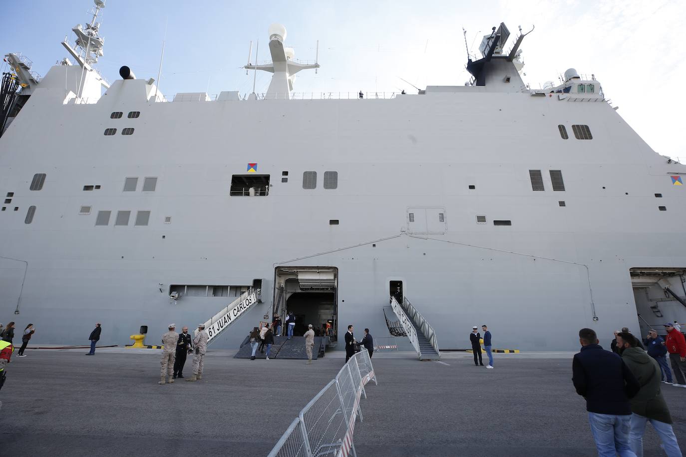 Cientos de personas han hecho largas colas durante la mañana de este sábado para poder subir y descubrir el interior del buque insignia de la Armada, el 'Juan Carlos I'. El portaaviones está atracado durante este fin de semana en el puerto de Valencia y este sábado se celebraba una jornada de puertas abiertas para poder subir y ver cómo es la vida dentro de un barco con más de 200 metros de eslora. 