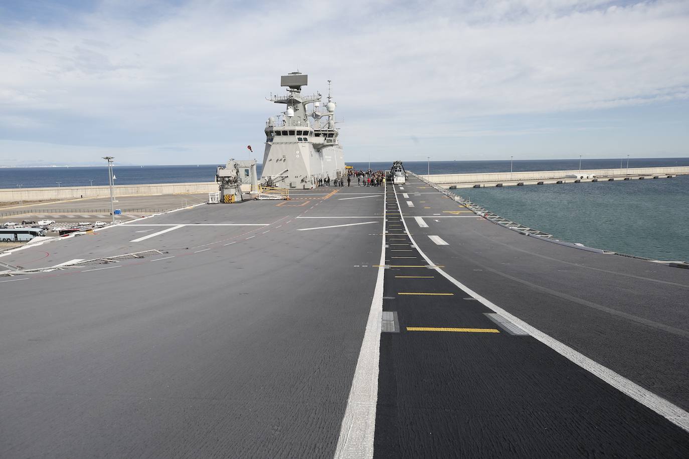 Cientos de personas han hecho largas colas durante la mañana de este sábado para poder subir y descubrir el interior del buque insignia de la Armada, el 'Juan Carlos I'. El portaaviones está atracado durante este fin de semana en el puerto de Valencia y este sábado se celebraba una jornada de puertas abiertas para poder subir y ver cómo es la vida dentro de un barco con más de 200 metros de eslora. 