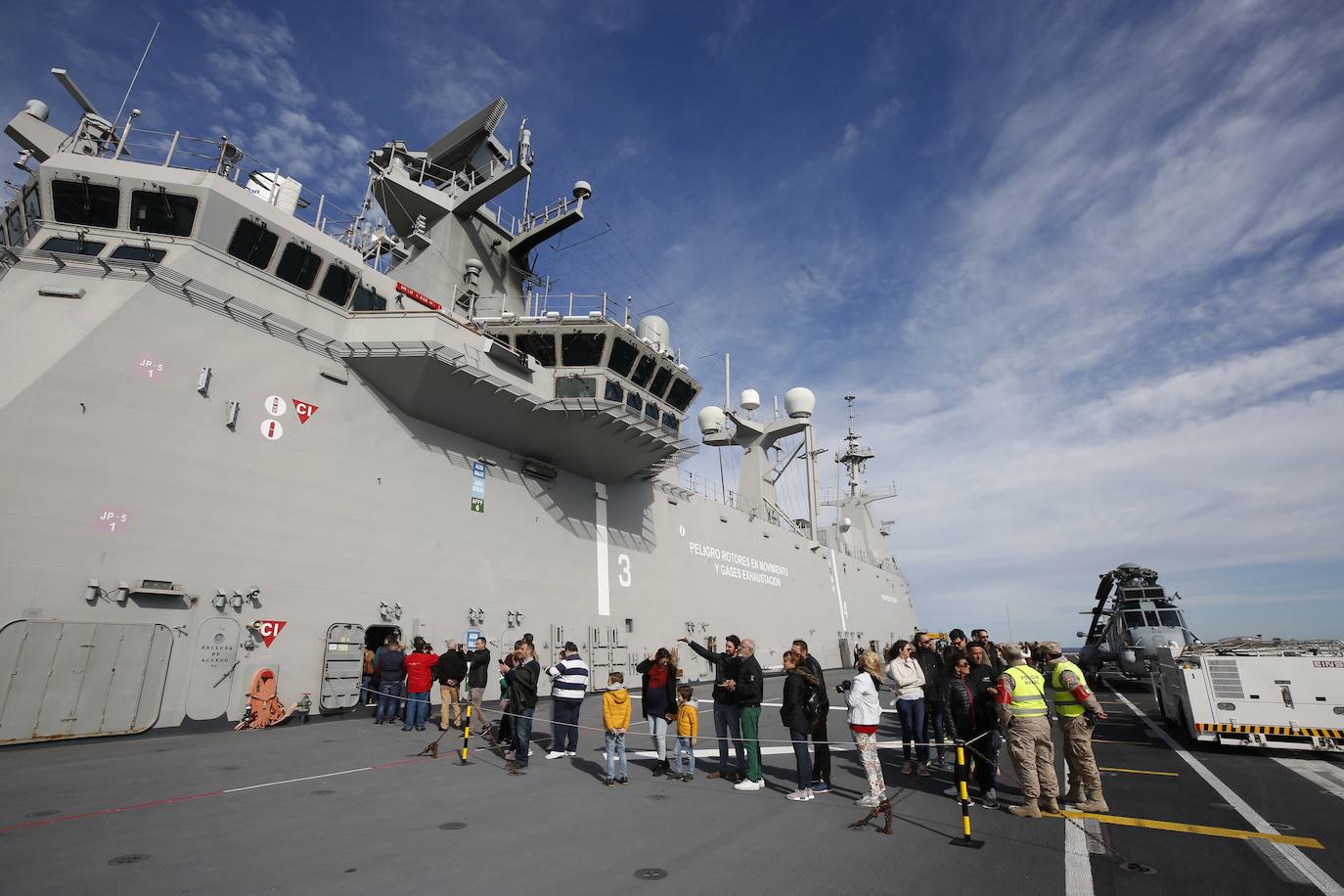 Cientos de personas han hecho largas colas durante la mañana de este sábado para poder subir y descubrir el interior del buque insignia de la Armada, el 'Juan Carlos I'. El portaaviones está atracado durante este fin de semana en el puerto de Valencia y este sábado se celebraba una jornada de puertas abiertas para poder subir y ver cómo es la vida dentro de un barco con más de 200 metros de eslora. 