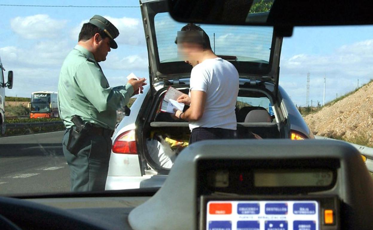 Un agente de la Guardia Civil multa a un conductor en plena carretera.