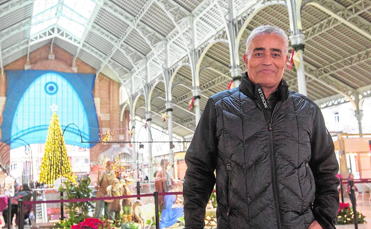 Osman Korkar, egiptólogo, junto al belén y el árbol de Navidad del mercado.