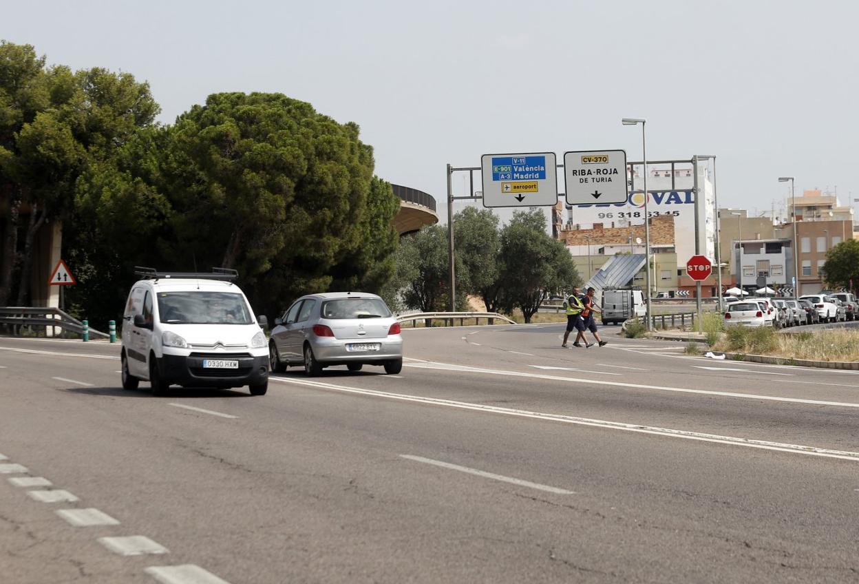 Dos peatones cruzan por la carretera. 