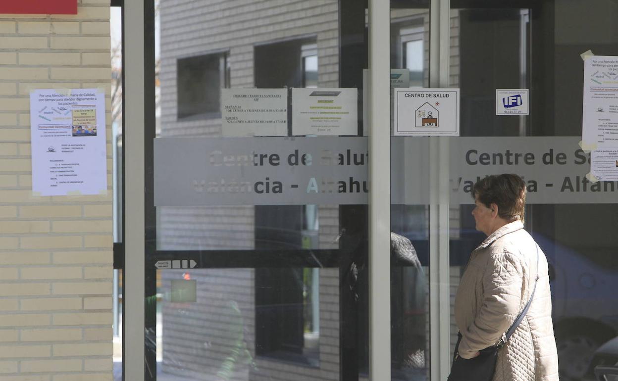 Una mujer entrando a un centro de salud. 