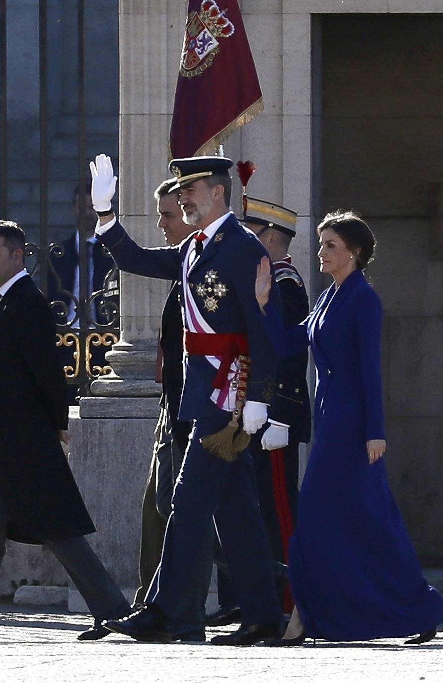 Felipe VI, acompañado por la Reina Letizia, ha presidido este lunes la ceremonia de la Pascua Militar en el Palacio Real. Para la ocasión, Doña Letizia ha elegido un elegante vestido de estilo esmoquin en azul intenso. La Reina ha combinado el diseño, largo hasta los pies, con unos zapatos stilettos en color negro y un peinado recogido acabado en un moño bajo.