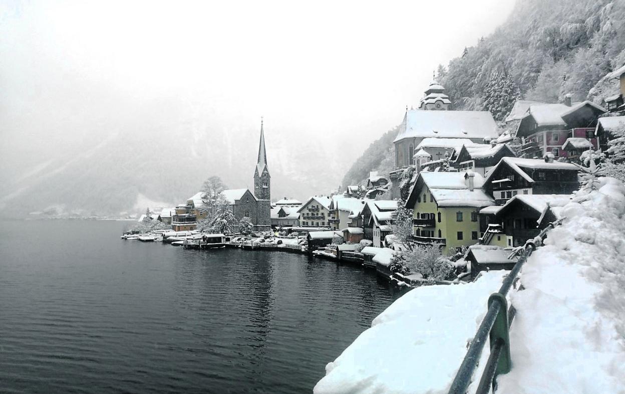 Hallstatt, cubierto de nieve estas navidades. Abajo, hordas de visitantes hacen cola para una excursión en barco. 