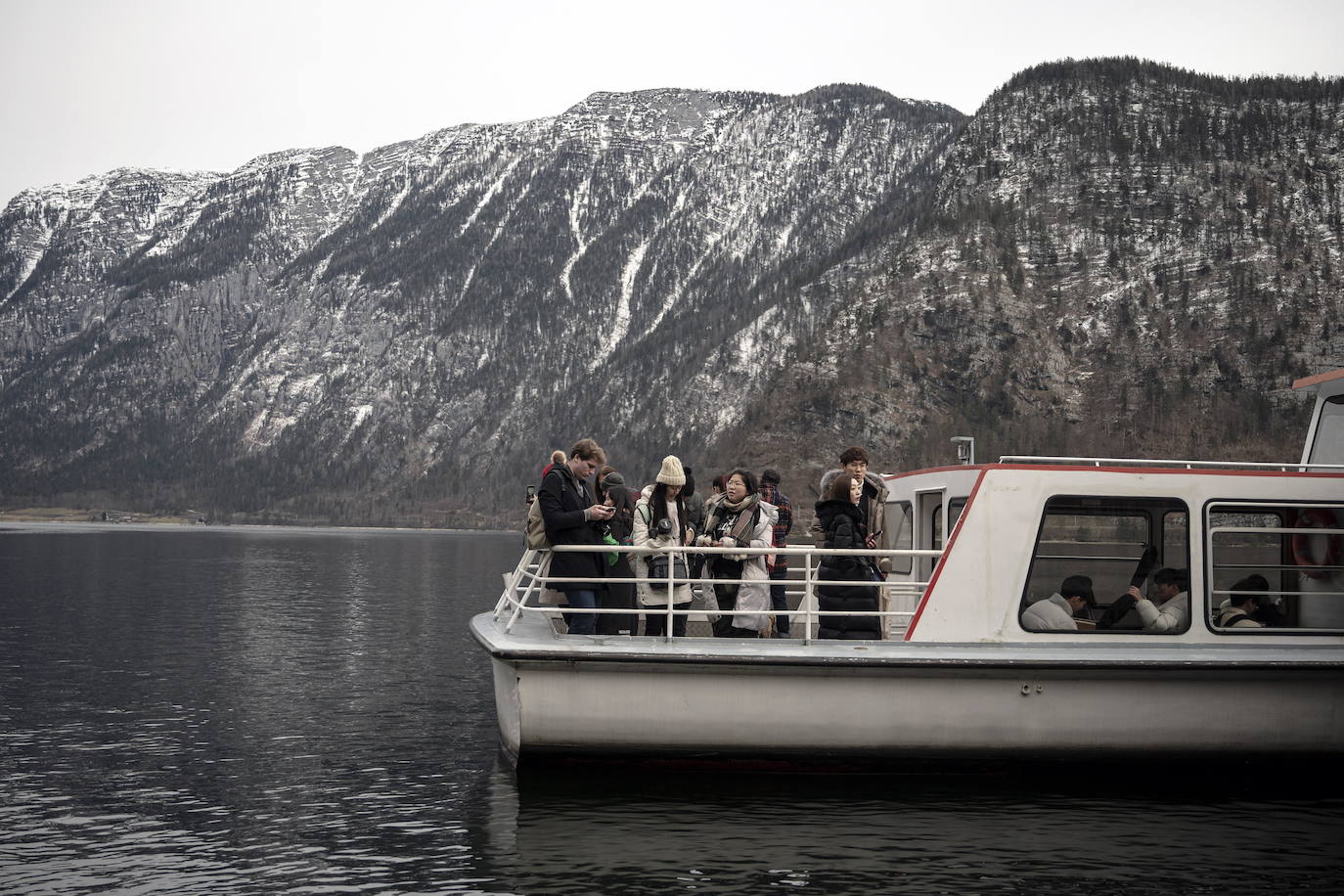 Hallstatt era hace diez años una villa idílica al borde de un lago de ensueño y aún lo sigue siendo, pero de otra manera. Lo que entonces le faltaba al pequeño pueblo austriaco, ahora le sobra. Tiene gente para dar y regalar, la hay por todas partes, tanta que hasta los visitantes se cuelan sin permiso en las casas en busca de un baño que no esté ocupado. En el pueblo residen 778 vecinos pero no lo parece porque apenas se les ve. Su presencia se diluye ante las riadas de personas que transitan por las calles en busca de un lugar vacío donde sacarse una foto mientras decenas de drones sobrevuelan los tejados para obtener imágenes impactantes. Hay turistas que llegan a la localidad convencidos de que se encuentran en un parque temático donde todo es de cartón piedra y todo está a la venta. Otros creen que están recorriendo el auténtico Arendelle, el reino de la película 'Frozen'. Hallstatt es un pueblo de moda, hasta ha sido calificado como «el más 'instagrameable' del mundo», y eso está siendo su ruina.