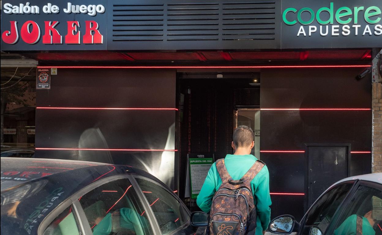 Un joven en la puerta de un local de apuestas.