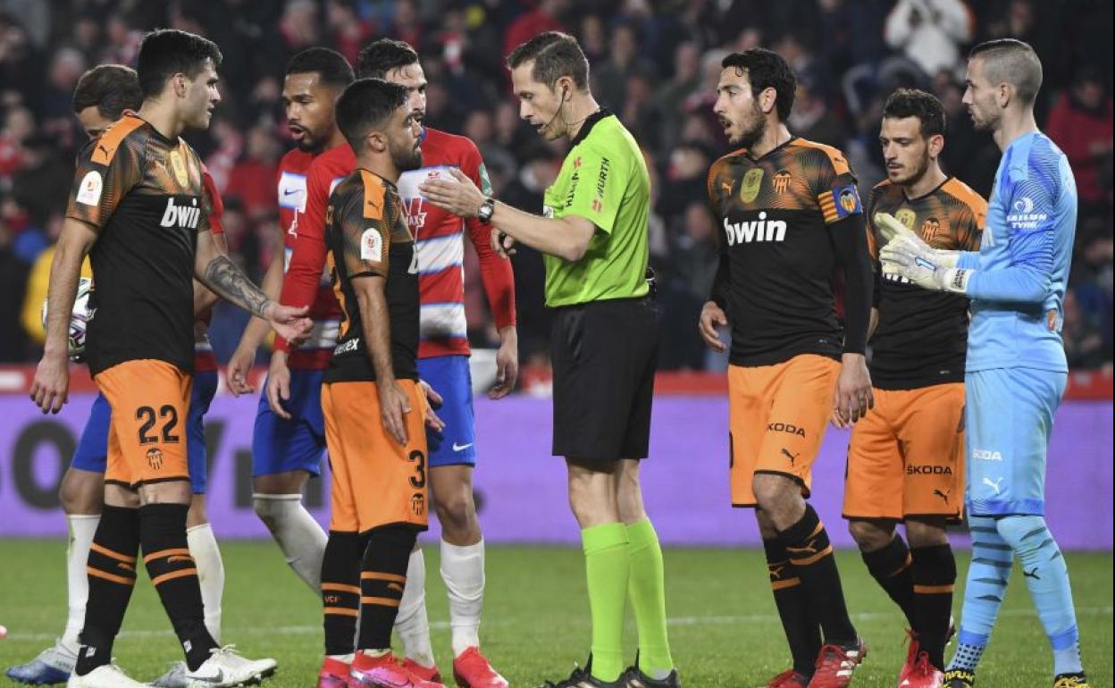 Los jugadores del Valencia protestan una acción durante el partido ante el Granada.