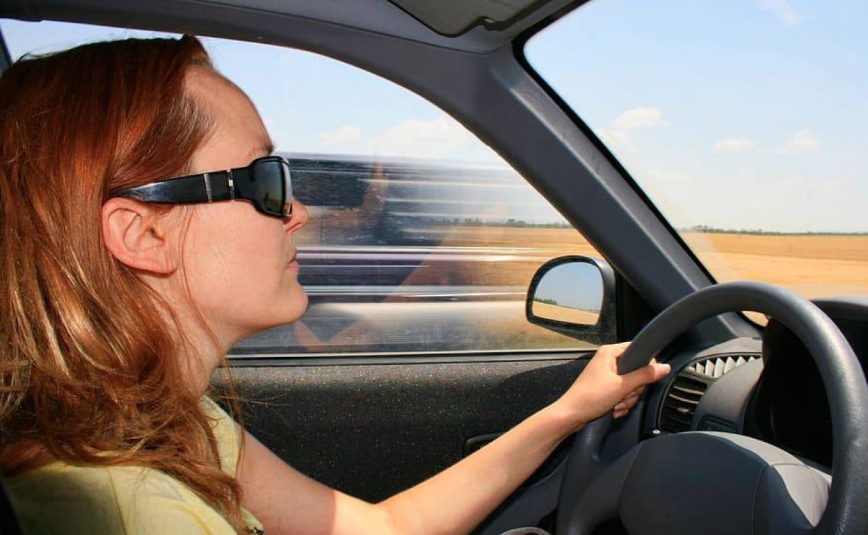 Una mujer, conduciendo un coche.