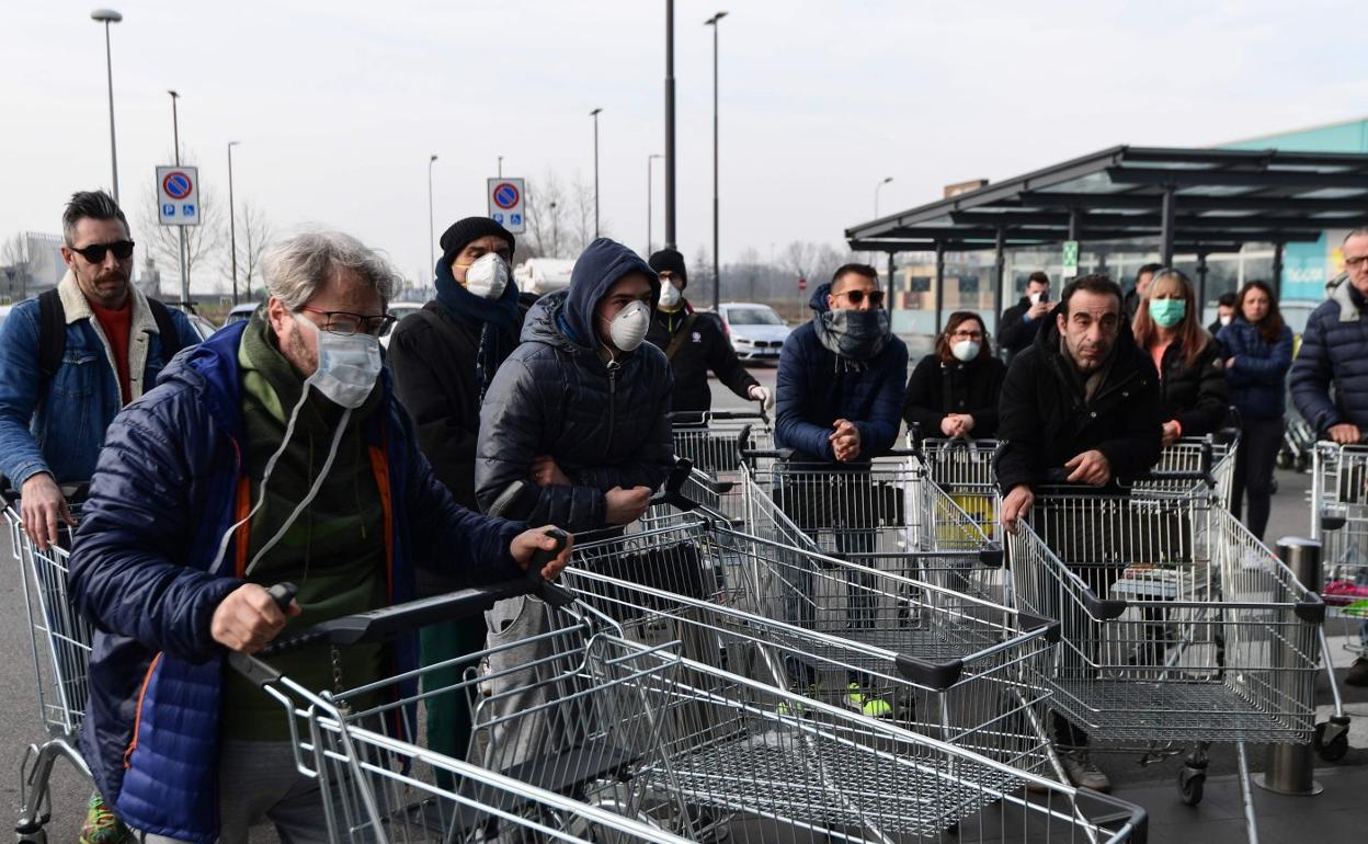 Vecinos de la ciudad de Casalpusterlengo esperan para poder entrar al supermercado para avituallarse.