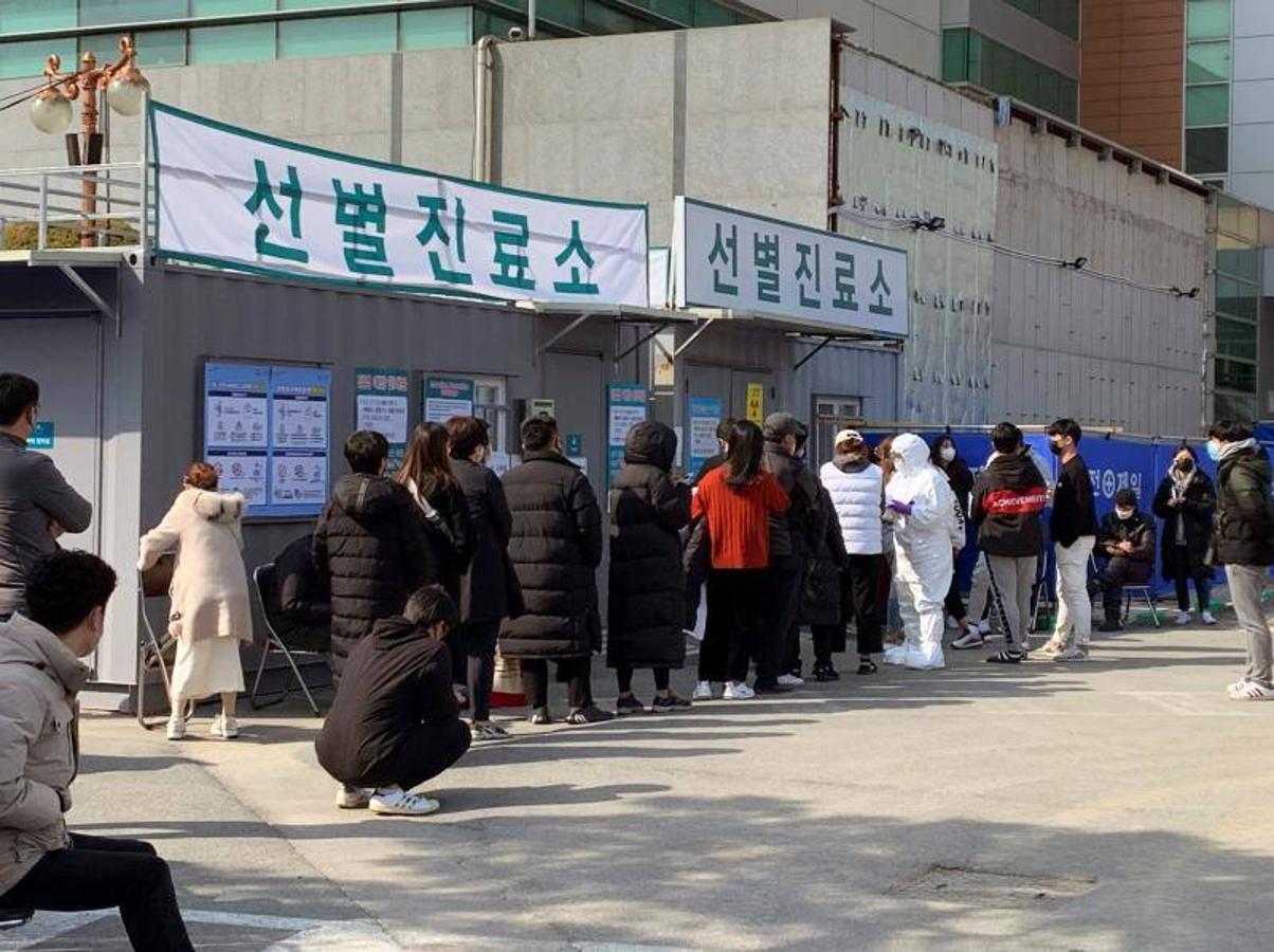 Decenas de pacientes hacen cola para describir sus síntomas y ser examinados en el exterior de la recepción especial instaurada en el Centro Médico Daegu