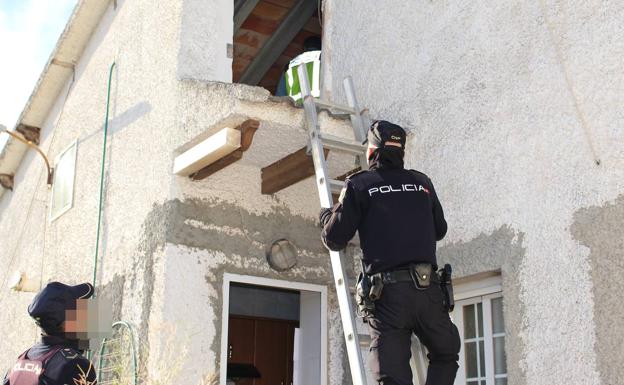 Agentes de la Policía Nacional registran el altillo de la vivienda de Bétera. 