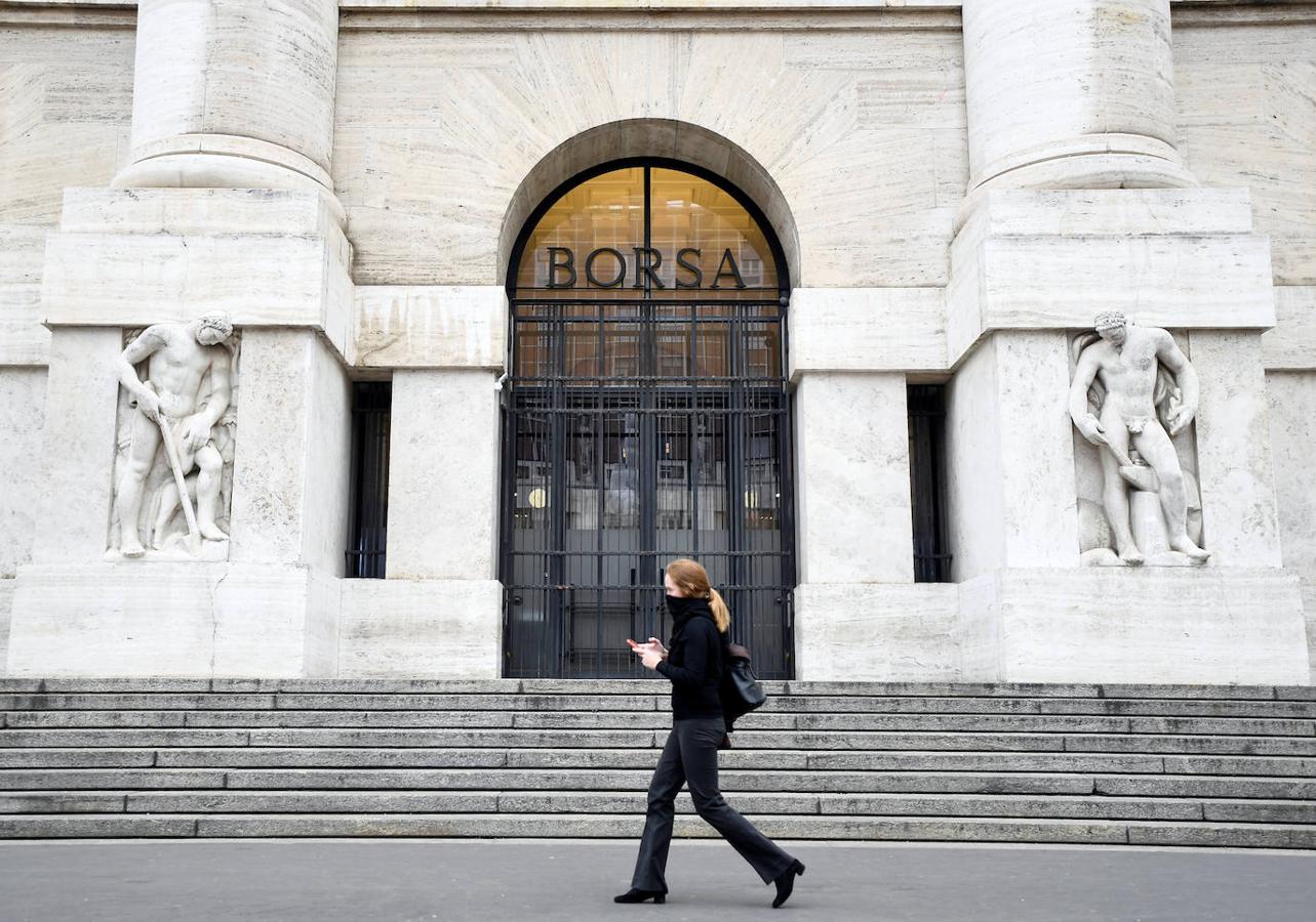 Una mujer pasa junto a la Bolsa de Valores en Milán.