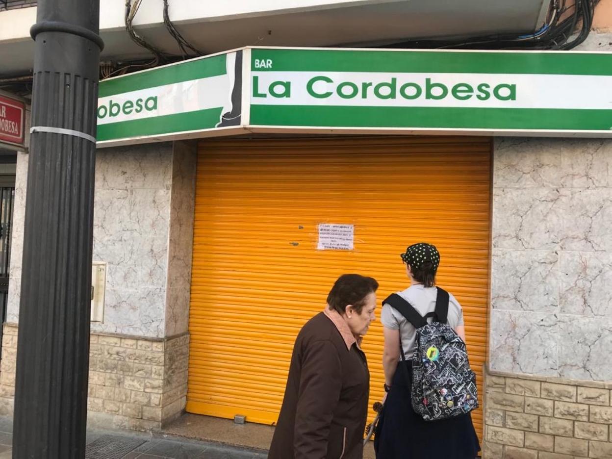 Una joven lee el letrero del bar de Paterna. lp