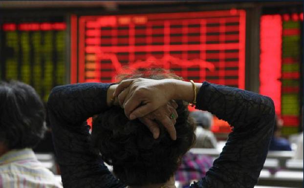 Una mujer comprueba la evolución de la bolsa de Shangái. 