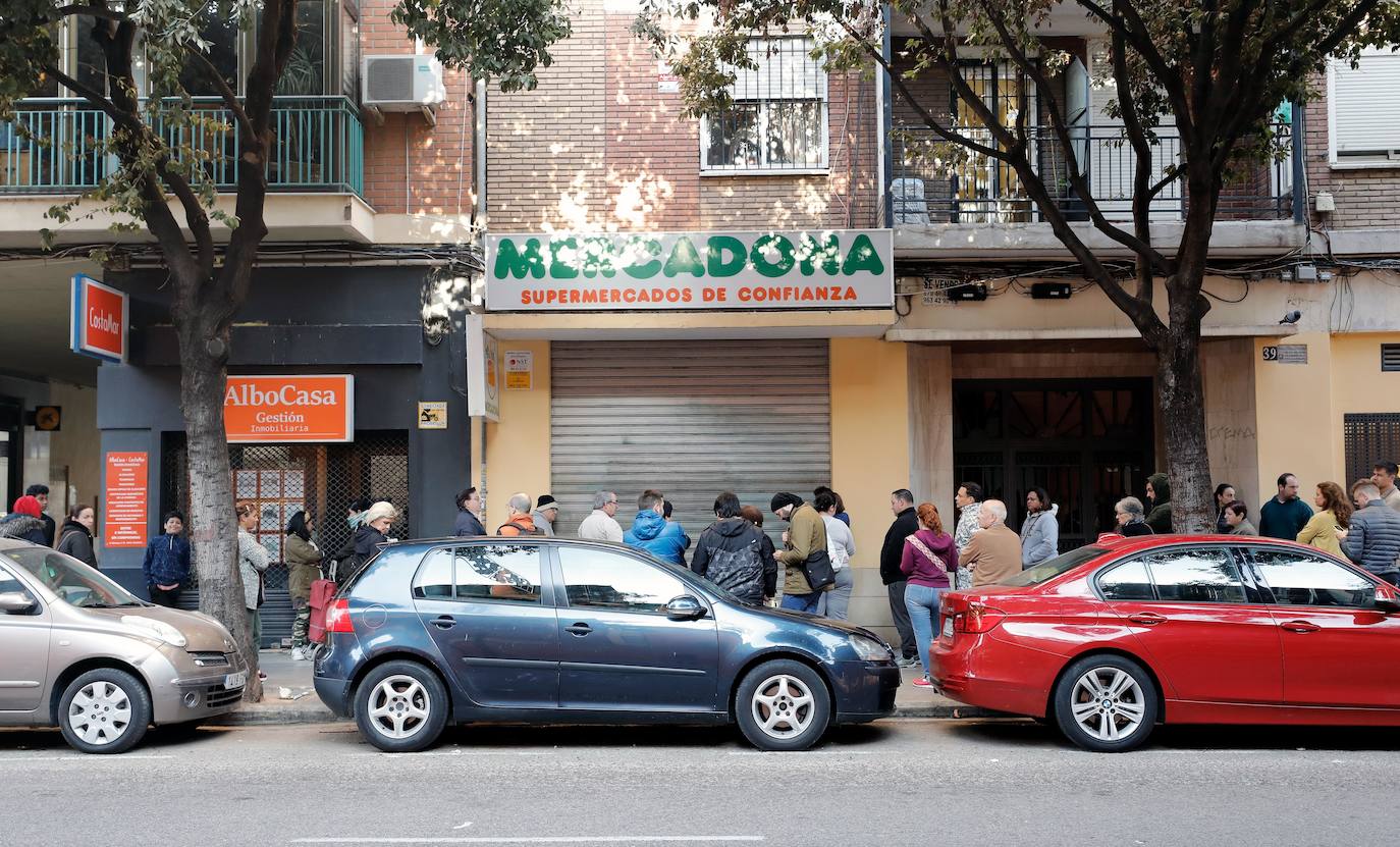 Sigue la avalancha de compras por el miedo a la pandemia del coronavirus. Los supermercados valencianos llevan ya varios días notando la falta puntual de productos como el agua embotellada, las pasta o el papel higiénico. Este sábado, multitud de tiendas y comercios de alimentación de Valencia han amanecido con largas colas de clientes esperando a la apertura de puertas. En la imagen, compradores esperan frente a las puertas de un Mercadona en el centro de Valencia.