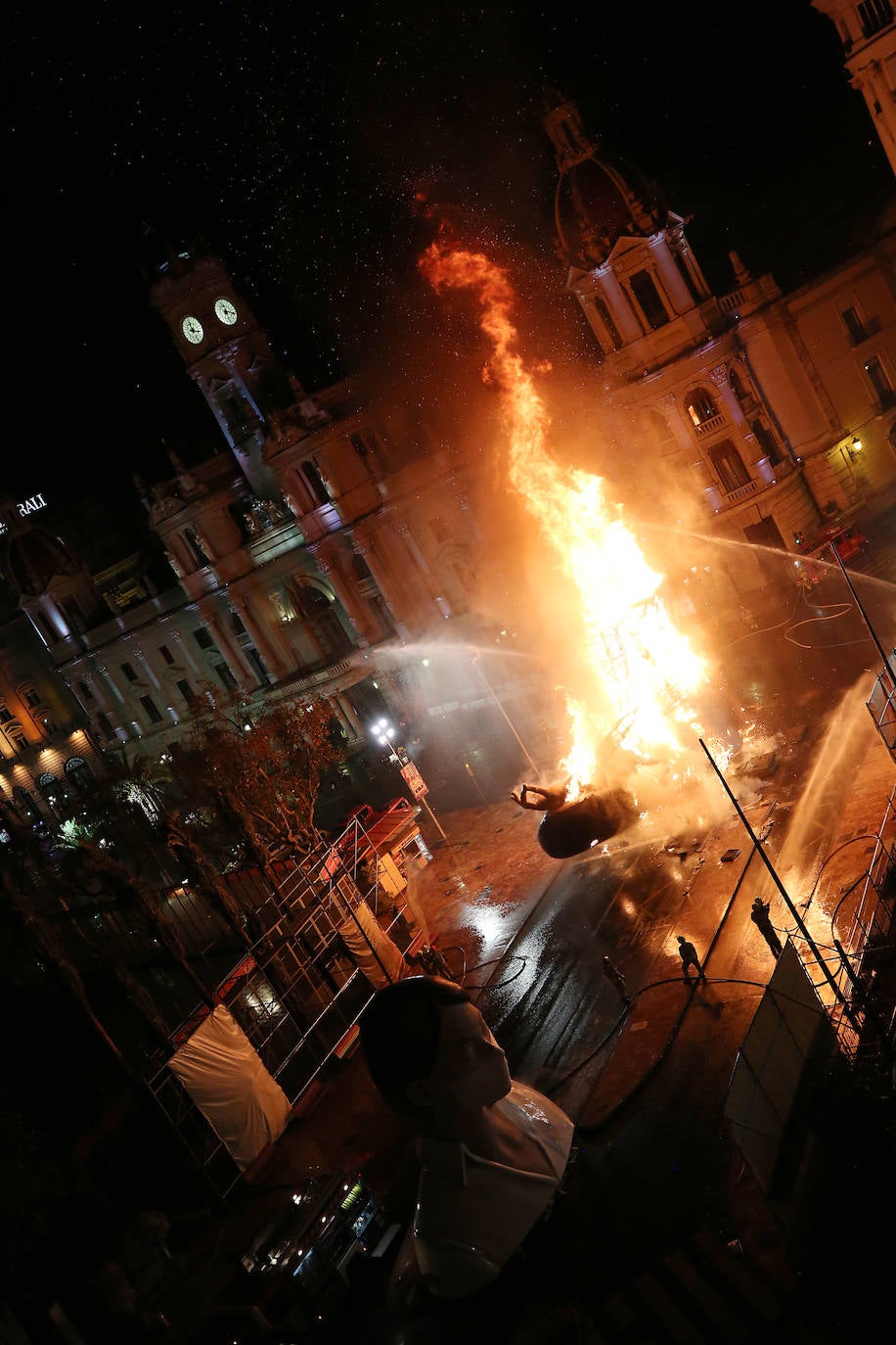 Los bomberos hacen arder la parte ya plantada de la falla del Ayuntamiento. La cabeza de la chica se guardará para la celebración de julio.