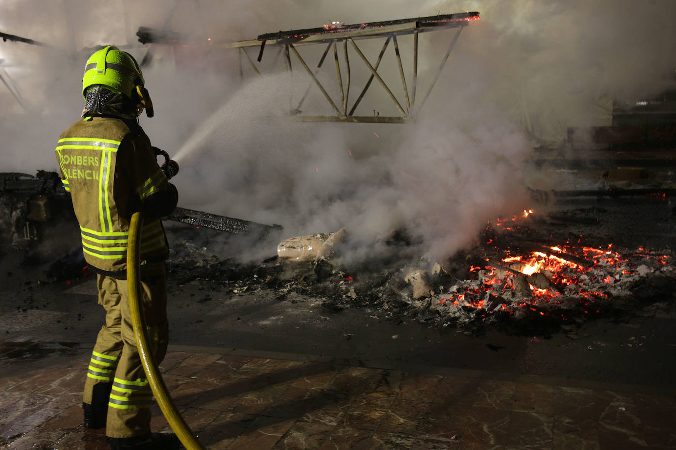 Los bomberos hacen arder la parte ya plantada de la falla del Ayuntamiento. La cabeza de la chica se guardará para la celebración de julio.